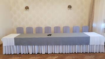 Conference room with a long table, herringbone floor, and eight chairs.