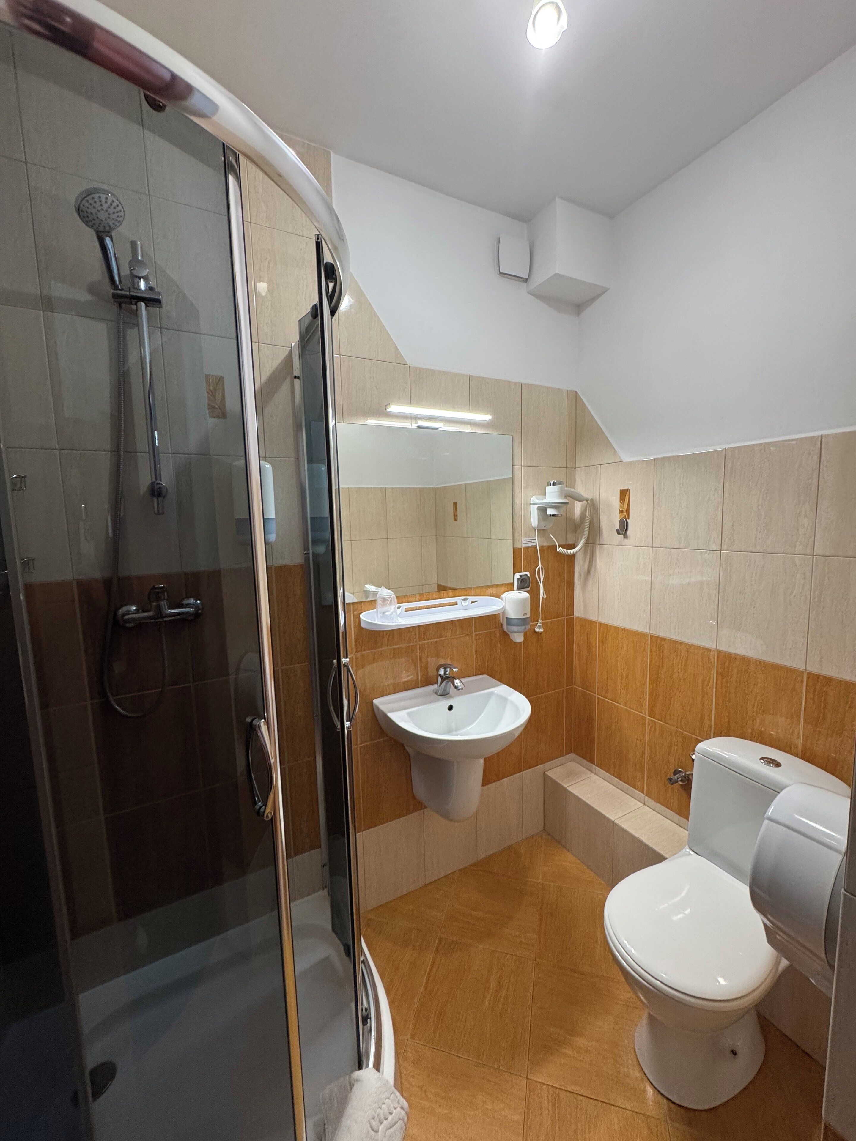 Une salle de bain moderne avec une douche à parois de verre, un lavabo et des toilettes.