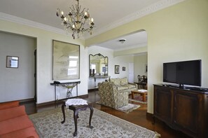 Apartamento família, várias camas | Sala de estar | TV de tela plana