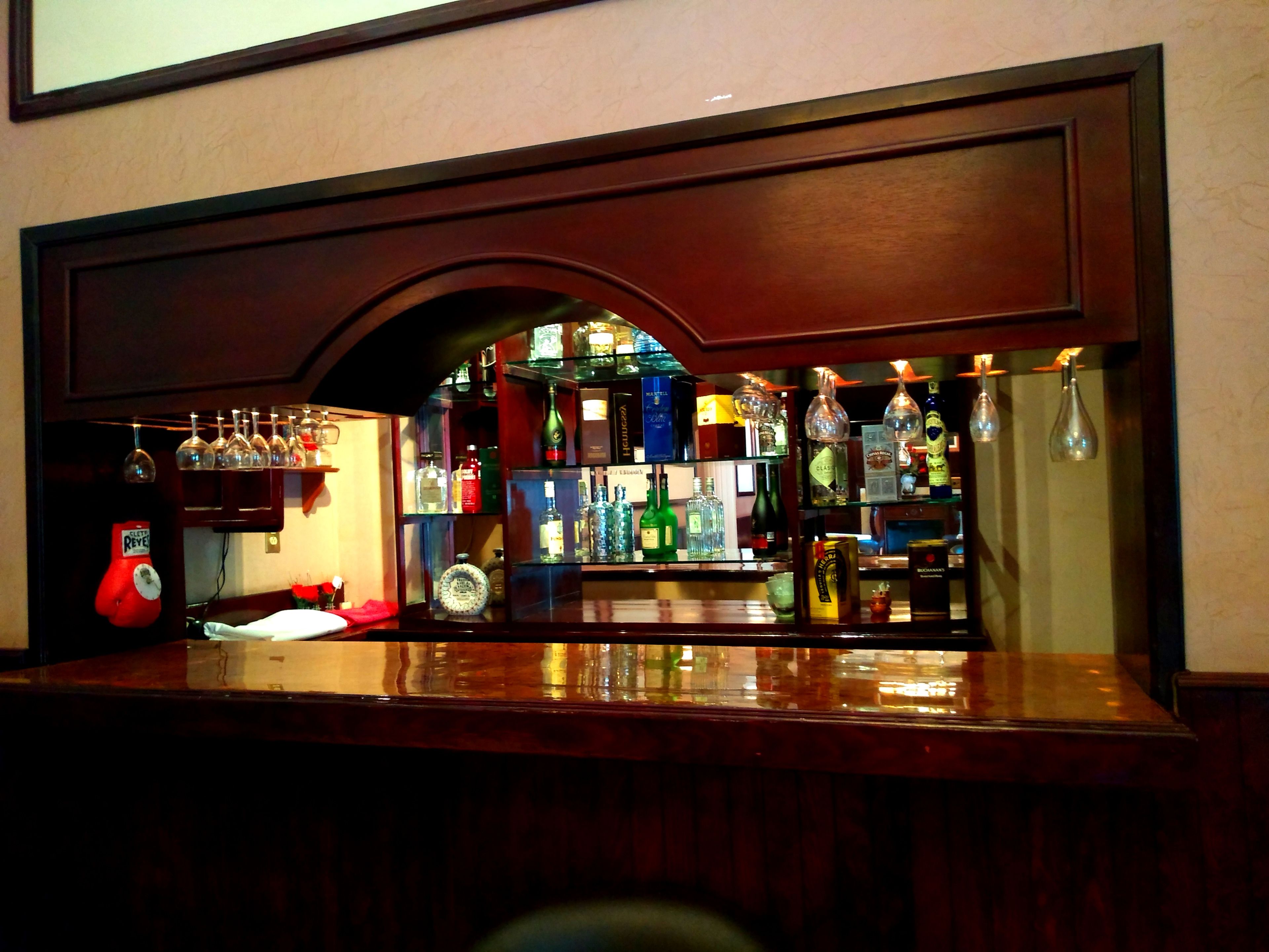 A bar area with shelves of liquor bottles and glasses.