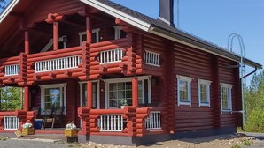 A log cabin with a porch, multiple windows, and a chimney. - Harjurinne by Interhome (Lestijärvi)