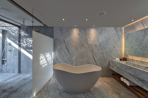 Een aparte badkuip en douche, handdoeken
