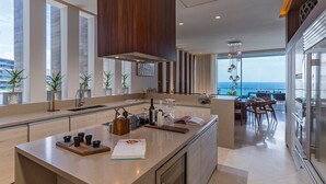 A modern kitchen with a large island, a dining area with a view, and a large window overlooking the ocean. - The Residences at Solaz, a Luxury Collection Resort, Los Cabos a Marriott Hotel (San José del Cabo)