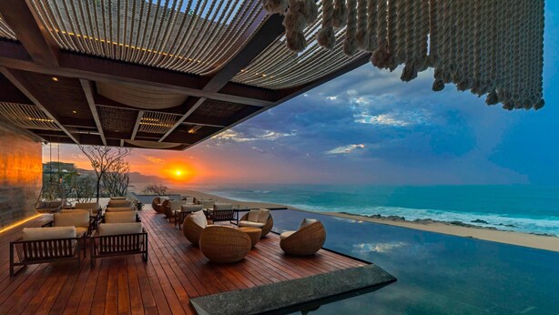 An infinity pool with a wooden deck and seating area overlooking the ocean at sunset. - The Residences at Solaz, a Luxury Collection Resort, Los Cabos a Marriott Hotel (San José del Cabo)