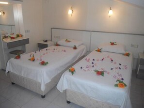 A hotel room with two single beds, each adorned with floral decorations.