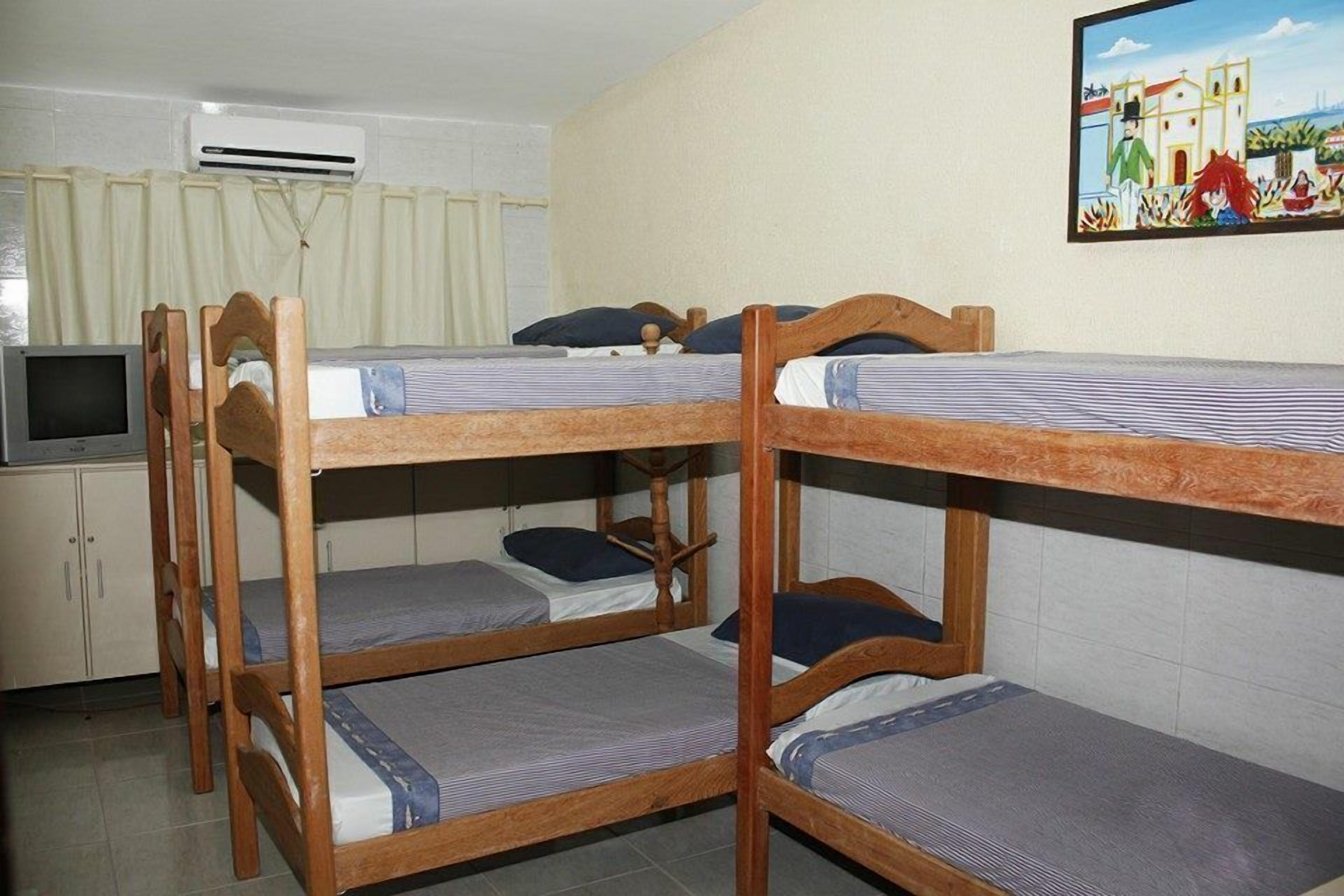 Un dormitorio con literas, un televisor y un cuadro en la pared.
