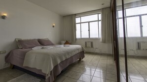 A bedroom with a bed, a window, and a radiator. - LineRio Vista Mar Copacabana 460 (Rio de Janeiro)