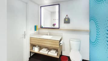 Ein modernes Badezimmer mit einem weißen Waschbecken, einer Holz-Kommode, einem Spiegel, einer Toilette und einer roten Mülltonne.