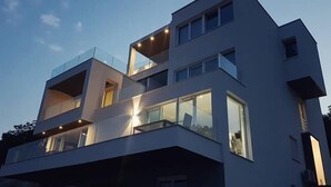 Een modern meerlaags gebouw met grote ramen en balkons.
