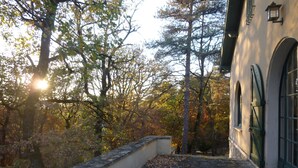 Un sendero de piedra que conduce a un edificio con ventanas de arco y un muro de piedra.