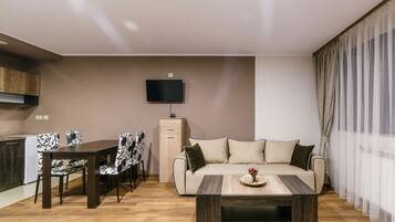 Estudio Confort, vista a la ciudad | Área de sala de estar | Televisión LED de 32 pulgadas con canales por cable y televisión