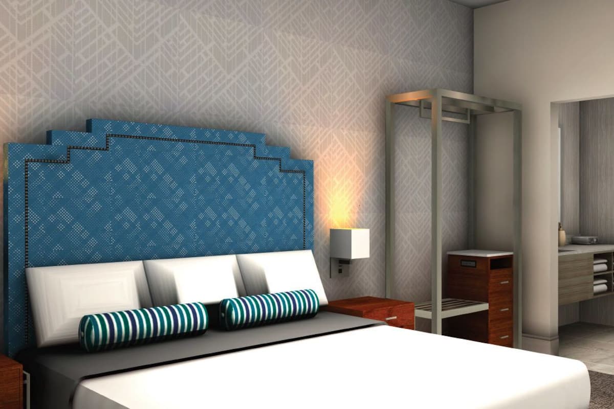 Un dormitorio moderno con una cama grande, dos mesitas de noche, un armario y un espejo.