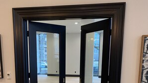 A room with a wooden floor, a black-framed door, and a white wall. - Harlow Hotel (Portland)