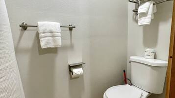 A small, clean bathroom with a toilet, a towel rack, and a toilet paper holder.