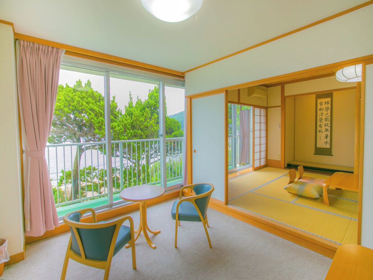 A room with tatami flooring, a sliding door leading to a balcony, and a traditional Japanese shoji screen.