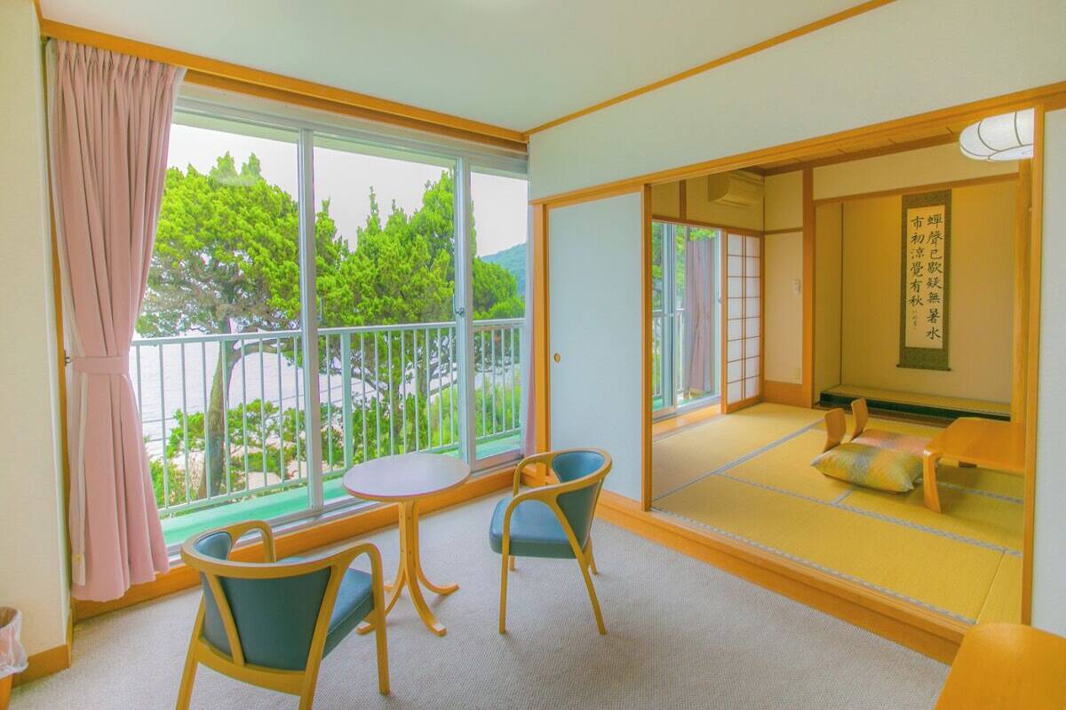 Quarto com piso de tatame, porta deslizante para uma varanda e tradicional divisória japonesa shoji.
