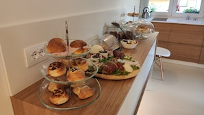Een ontbijtbuffet met diverse gebakjes en toppings op een houten toonbank.