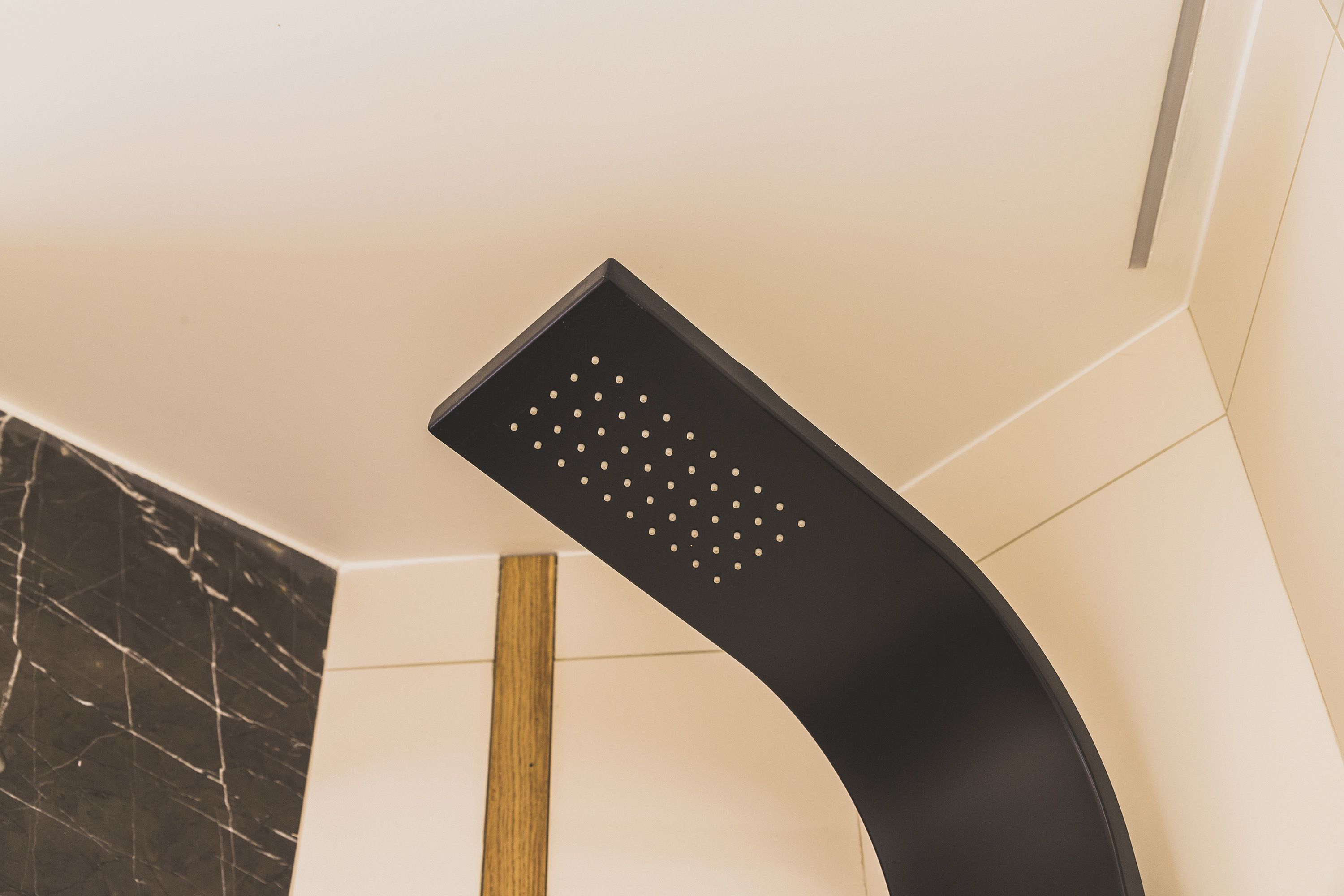 A modern showerhead with a curved design and multiple nozzles.