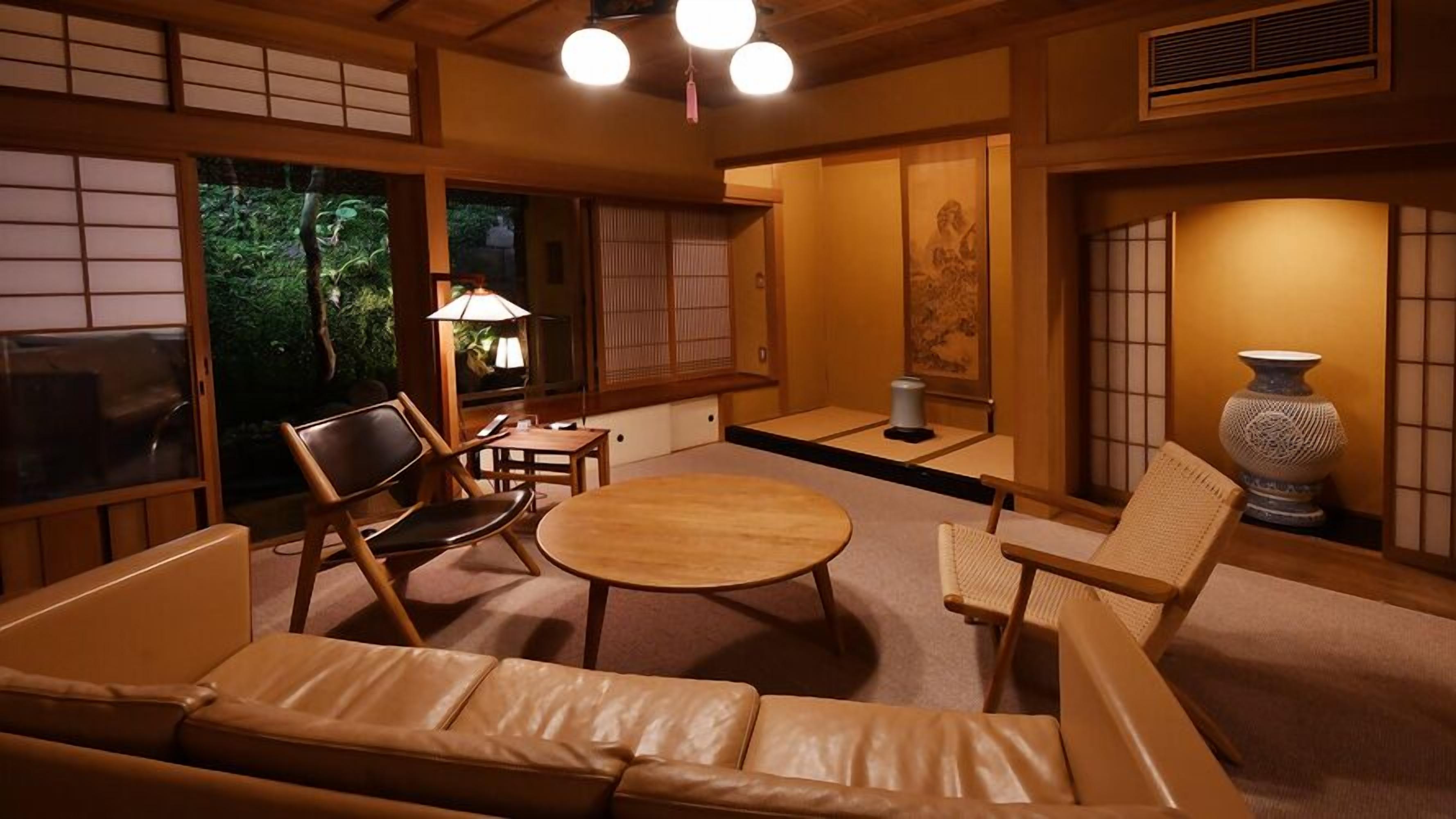 Une pièce de style japonais traditionnel, avec un sol recouvert de tatamis, une table basse et un canapé.