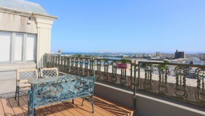 A balcony with a metal table and chairs, a view of the cityscape, and a railing. - Hotel Castle inn Tsu (Tsu)