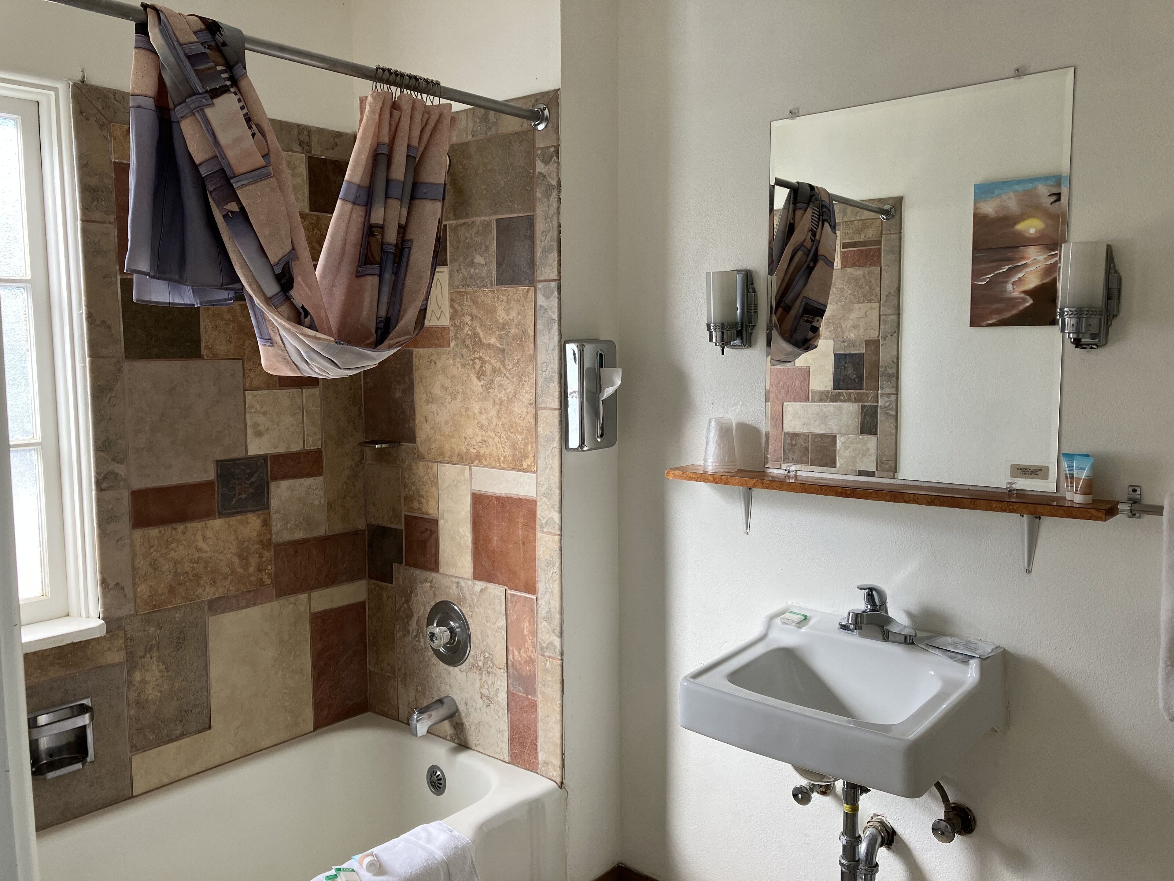 Une salle de bain équipée d’une douche, d’un lavabo, d’un miroir et d’un porte-serviettes.