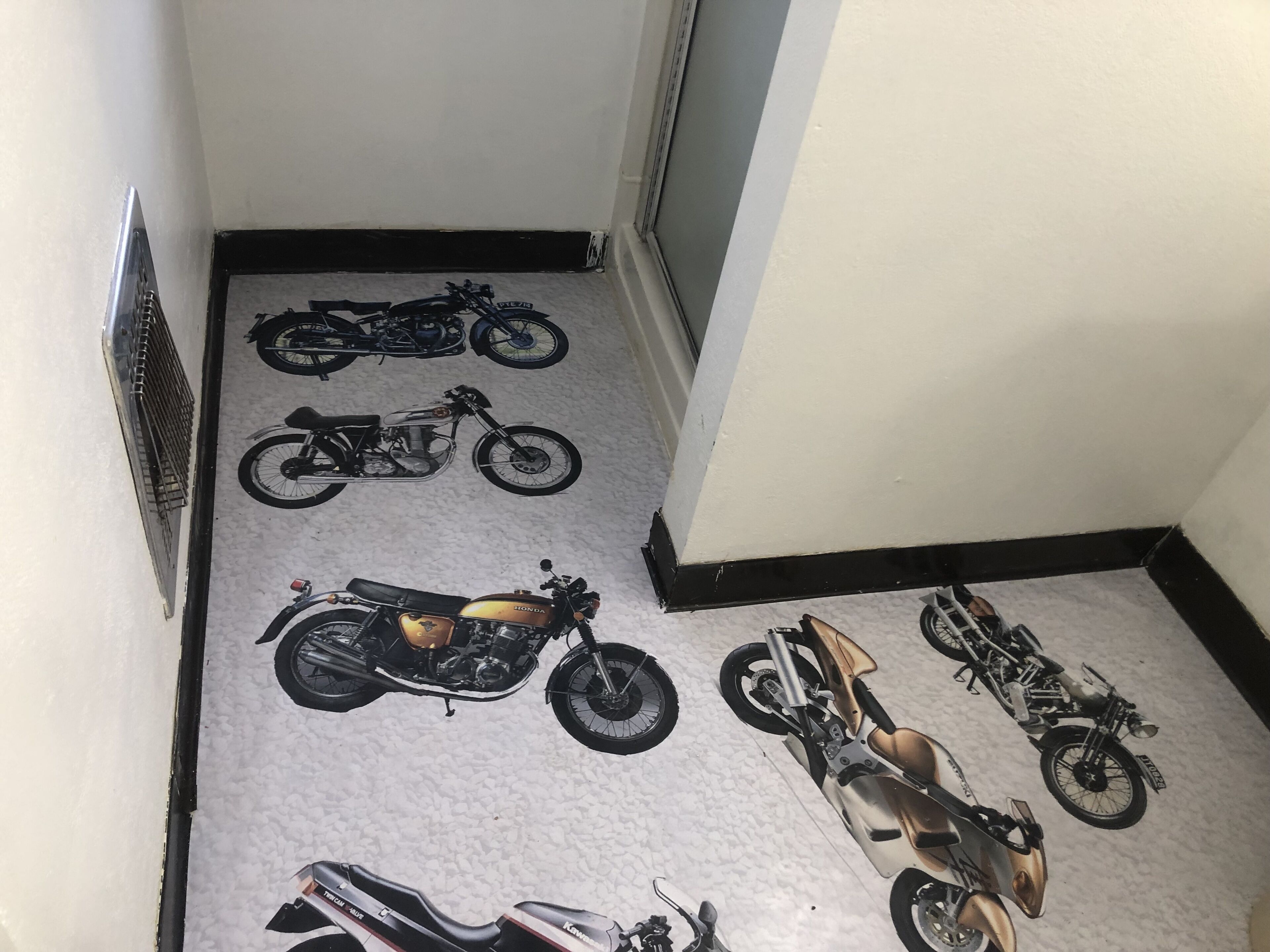 Un pasillo con un diseño de piso que presenta varios modelos de motocicletas.