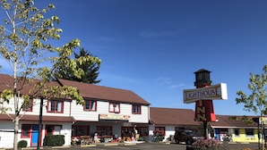 A historic building with a sign reading "LIGHTHOUSE INN" and "NO STRANGERS HERE JUST FUTURE FRIENDS". - Florence Lighthouse Inn (Florence)