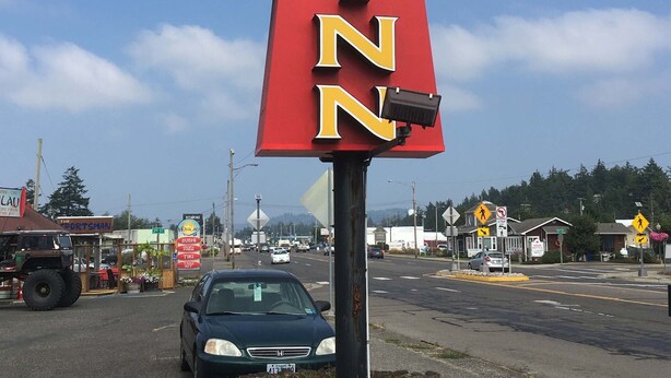 A sign for a Lighthouse Inn with a vacancy notice.