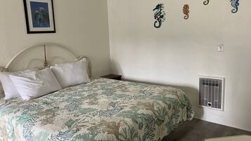 Un dormitorio con una cama, un cuadro en la pared y decoración de caballitos de mar.