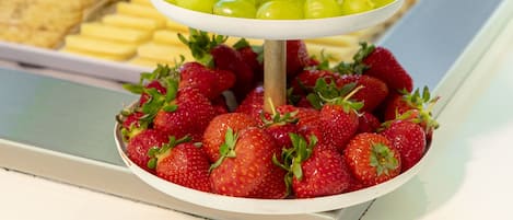 Una exhibición de fruta de tres niveles con uvas, fresas y arándanos.