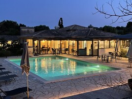 Una piscina al aire libre de temporada, sombrillas
