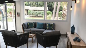 A modern living room with a sofa, two armchairs, a coffee table, and a wooden side table with decorative items. - Prea Gianca (Bonifacio)