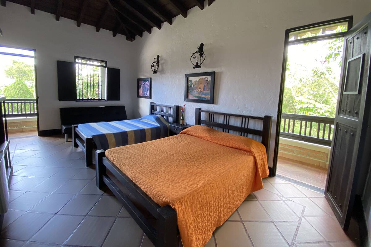 A room with two beds, a TV, and a balcony.