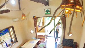 A restaurant with wooden tables and benches, a chalkboard menu, and a hanging light fixture. - Tanegashima Minshuku Yu-yu (Minamitane)
