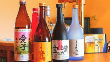 Bottles of Japanese liquor on a table with a laptop and a book in the background.
