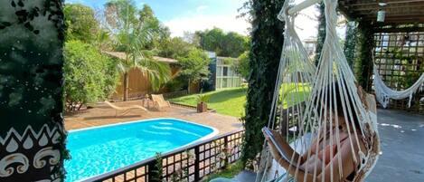 Een buitenzwembad en ligstoelen