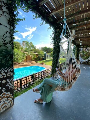 Una piscina al aire libre, sillones reclinables de piscina