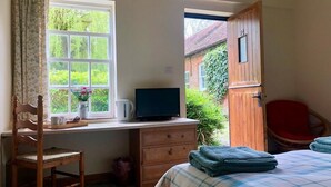 A bedroom with a bed, a desk with a computer, a chair, and a window with curtains. - Beachborough Park (Folkestone)