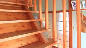 A wooden staircase with a traditional design, leading to an upper level. - Minshuku Urashima (Minamiizu)
