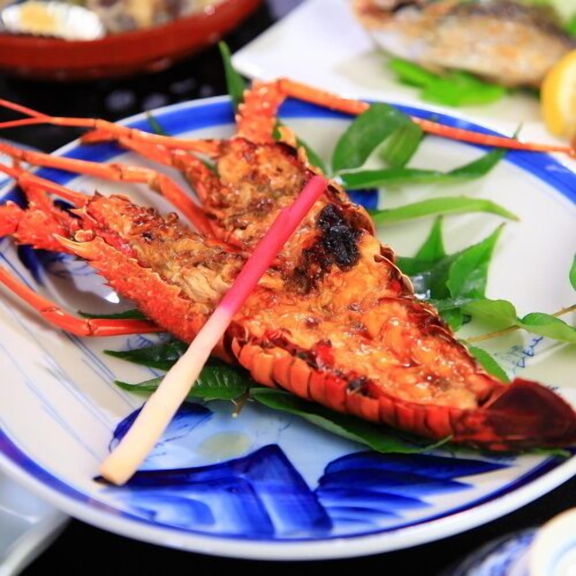A lobster on a plate with green leaves.