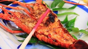A lobster on a plate with green leaves.