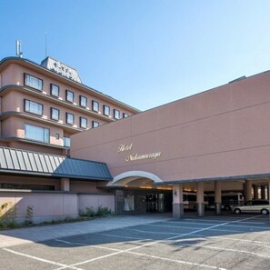 A hotel with a large parking lot and a building facade with the name 'Hotel Nakamura' visible. - Hotel Nakamuraya (Shiojiri)
