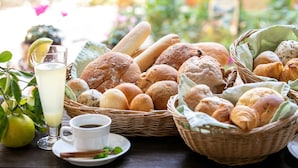 A table with various breads, a glass of milk, and a cup of coffee. - Petit Hotel Clanvert (Hagi)