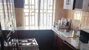 Une cuisine équipée d’une cuisinière à gaz, d’un évier et de placards.