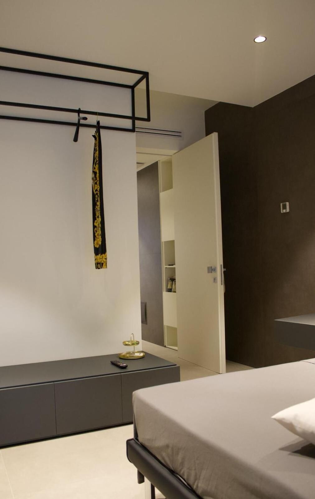 A modern bedroom with a bed, bedside table, and a wardrobe.
