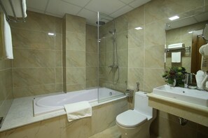 A bathroom with a bathtub, toilet, and a sink with a mirror. - 7S West Lake Home Hotel & Spa (Hà Nội)