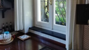 Una cocina con encimera de madera, una ventana con cortinas y vistas a la vegetación.