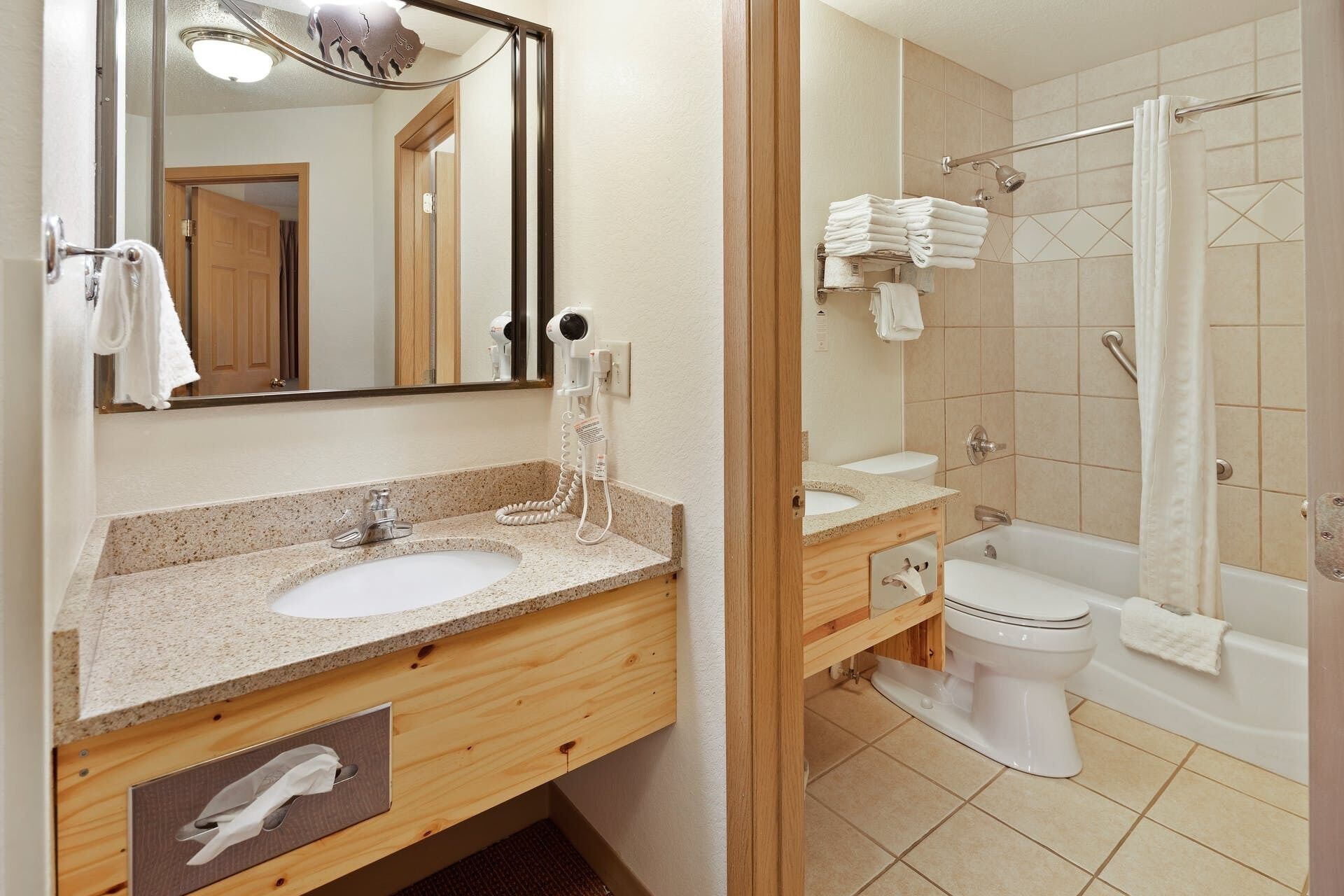Baño con lavamanos, espejo y zona de ducha.