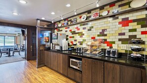 Una cocina moderna con una estación de café, microondas y tostadora.