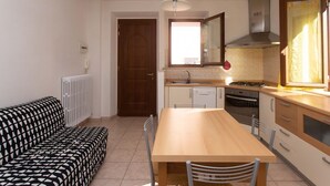 A compact kitchen with a dining table, chairs, a sofa, and a window. - N032 - Numana, new three-room apartment with terrace on the left (Numana)